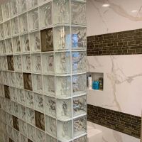 Custom tile niche in a glass block shower with brown glass blocks - Innovate Building Solutions
