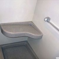 Extended curved bench seat in a solid surface shower system 