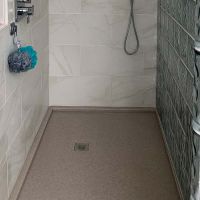 Cultured granite shower pan with a glass block wall with a square drain - Innovate building solutions 