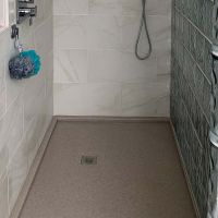 Cultured granite shower pan with a glass block wall with a square drain - Innovate building solutions