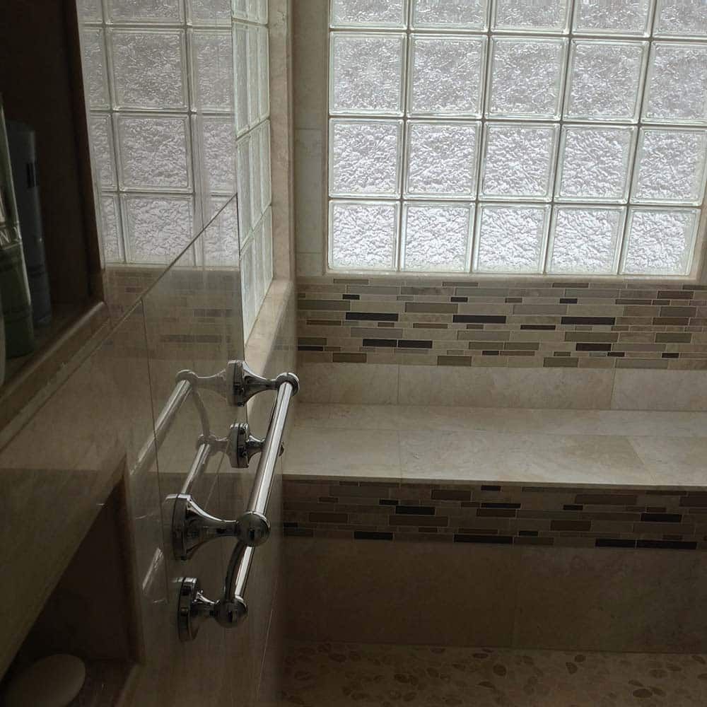 Glass block shower window with a tile and stone bench seat Innovate Building Solutions Columbus Glass Block division 