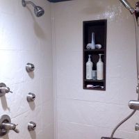 Dark brown contrasting tall recessed shampoo niche with matching crown molding - Innovate Building Solutions