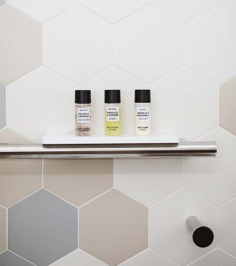 Prestige grab bar with a solid surface soap dish in a glass block shower - Innovate Building Solutions