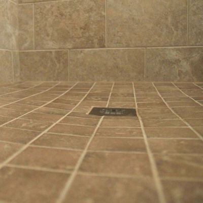Square drain cover in a ready for tile shower pan - Innovate Building Solutions