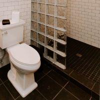 Glass block wall with a mosaic tile floor with a square drain in a boutique hotel in New York - Innovate Building Solutions