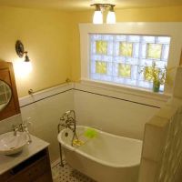 Vintage tub with bright yellow multi-size glass block bathroom window - Innovate Building Solutions 
