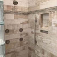 Vertical niches and a soap shelf in a ceramic wood plank look shower - Innovate Building Solutions