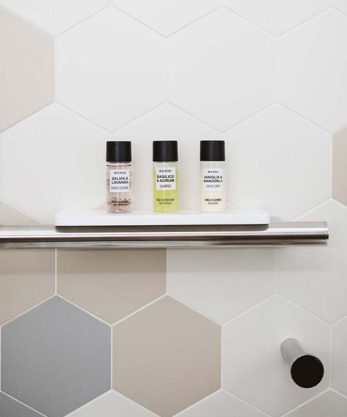 Prestige grab bar with bottles on shelf and a Corian shelf