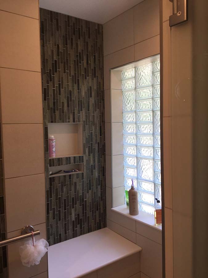 Shower niche, bench and high privacy glass block window in a transitionalist shower - Innovate Building Solutions
