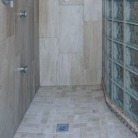 Square drain in a expanded polystyrene shower pan with a glass block wall - Innovate Building Solutions