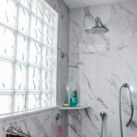 Ceramic marble look tile shower with privacy of a wave pattern glass block shower window - Innovate Building Solutions 