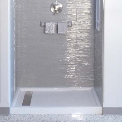 Linear drain in a white solid surface shower pan - Innovate Building Solutions