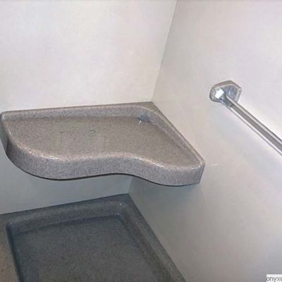 Extended corner bench seat in a traditional solid surface shower - Innovate Building Solutions